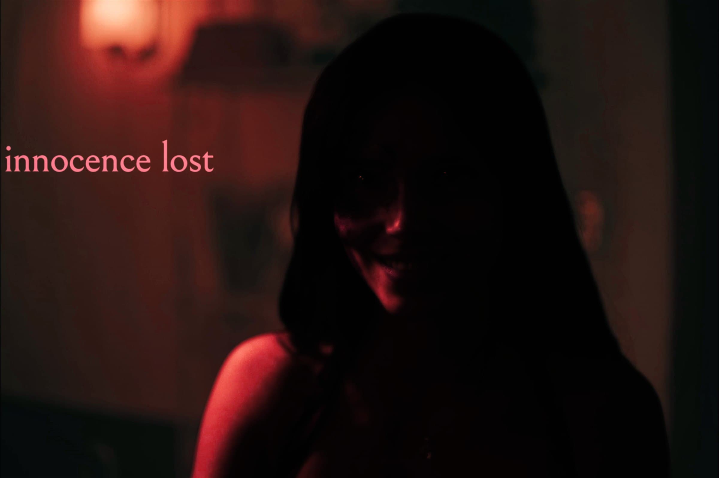 Nikki Freeman, red-lit and smiling in a doorway, captioned 'innocence lost.'