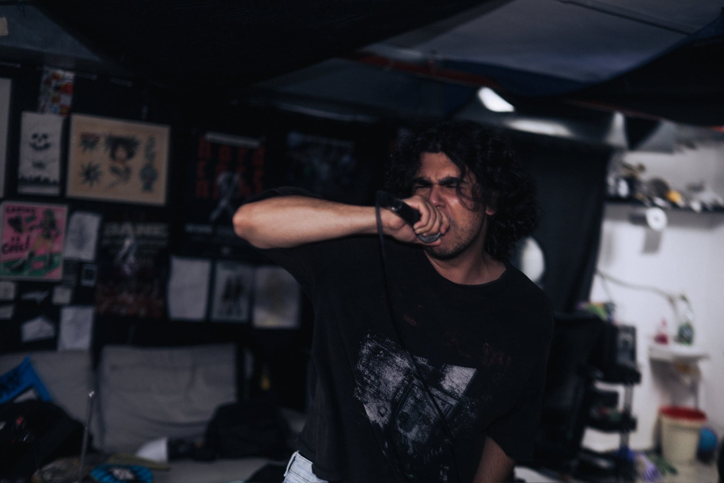 Black and white — the vocalist recoils mid-scream, motion blurring the frame.